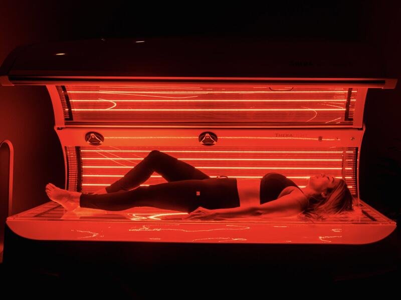 Client receiving LED face mask treatment in modern MedSpa